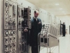 Technician standing beside FST-2 computer - 1985
